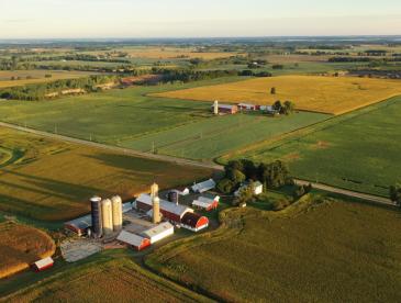 A farm with red barns and silos, viewed from overhead.