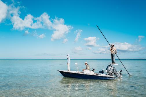 fishers in a boat on clear water and under a blue sky in the Bahamas