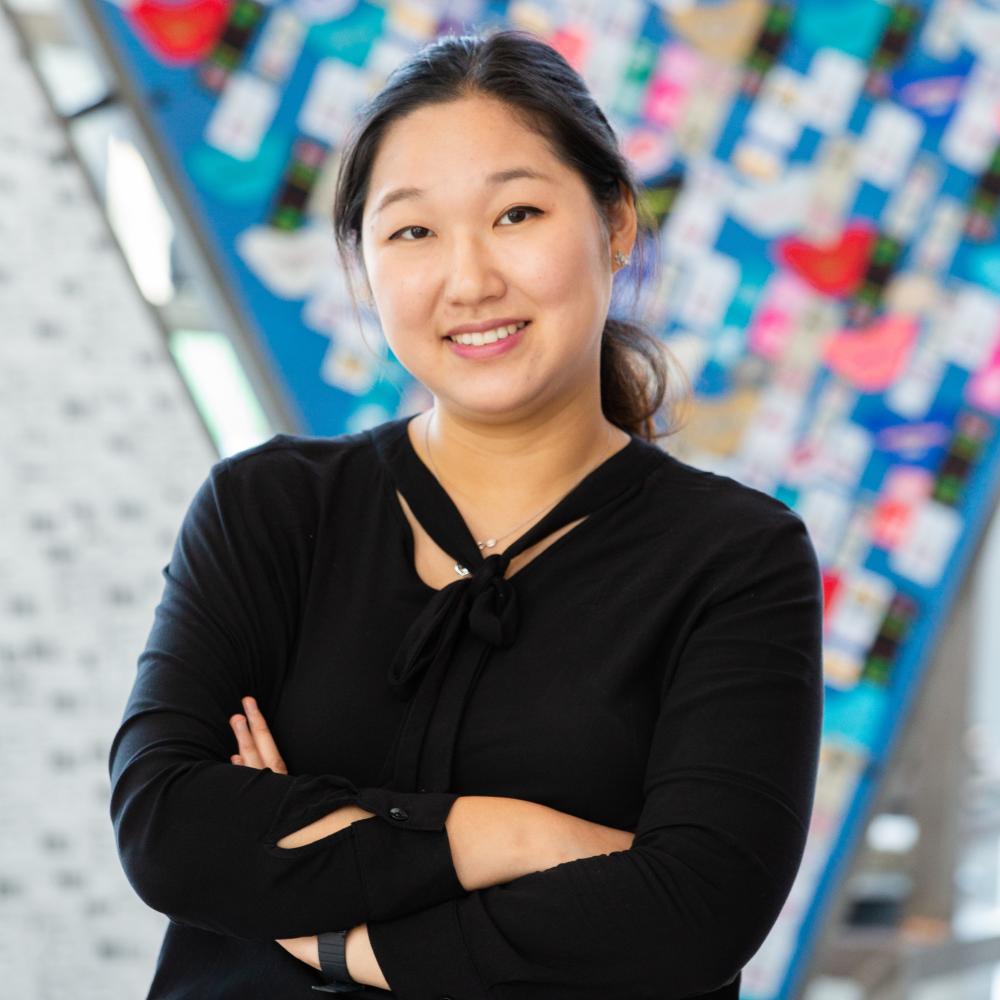 A Climate Corps fellow poses for a portrait, smiling, at New Balance in Boston.