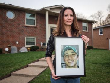 A mother holds a photo of her son.