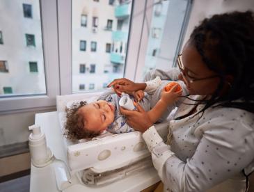 A mother applying lotion to her baby