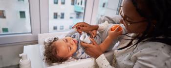 A mother applying lotion to her baby