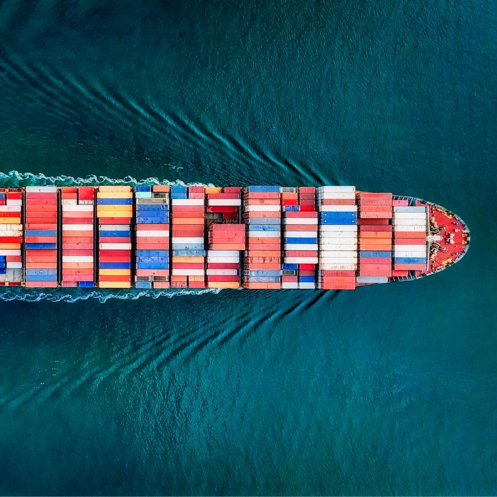 A cargo ship filled with shipping containers on the move.